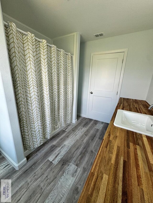 bathroom featuring a shower with curtain, hardwood / wood-style flooring, and sink