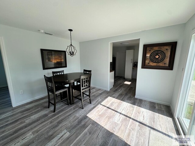 dining space featuring dark hardwood / wood-style floors and a chandelier