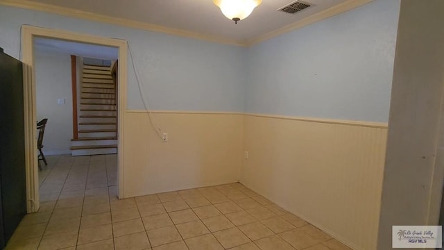 spare room with crown molding and light tile patterned flooring