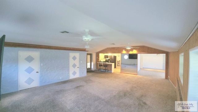 unfurnished living room with ceiling fan, lofted ceiling, and carpet flooring