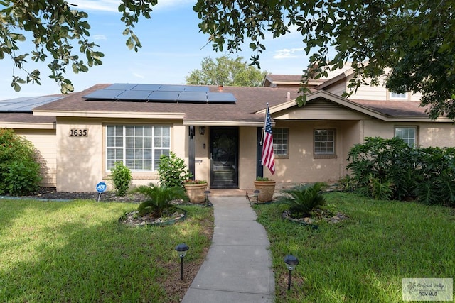 view of front of home featuring solar panels and a front yard