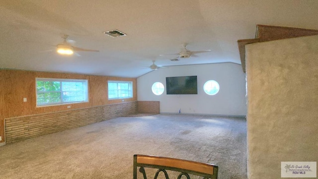 interior space with vaulted ceiling, ceiling fan, and carpet