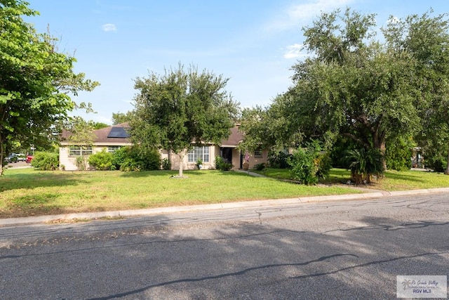 view of front of house featuring a front yard and solar panels