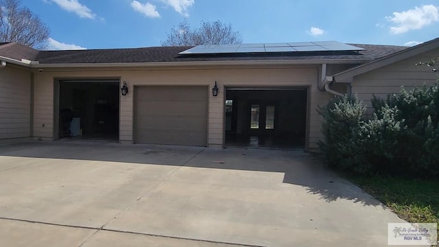 doorway to property featuring a garage and solar panels