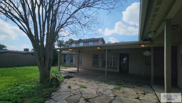 back of property featuring a yard and a patio area