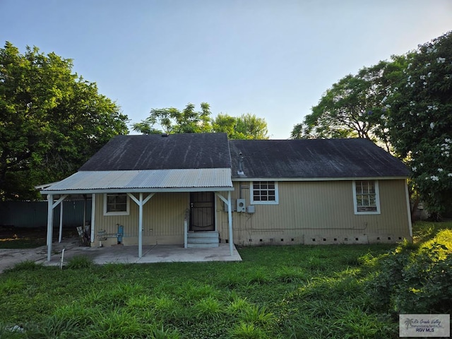 rear view of property featuring covered porch and a lawn