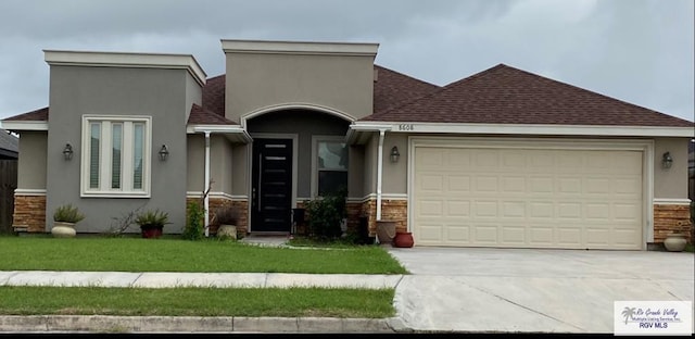 view of front of home featuring a front lawn, a garage, driveway, and stucco siding