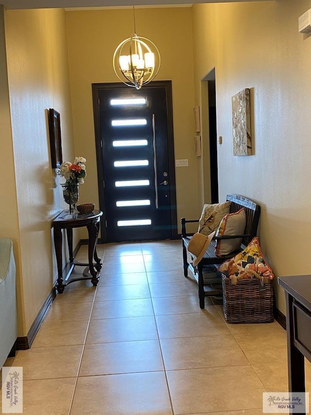 foyer featuring an inviting chandelier, light tile patterned floors, and baseboards