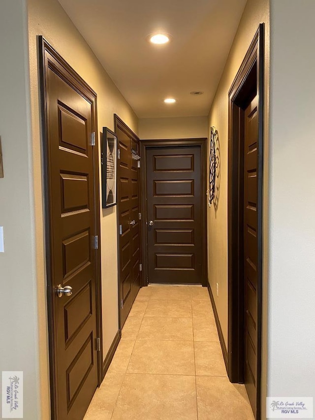corridor featuring light tile patterned floors, recessed lighting, and baseboards