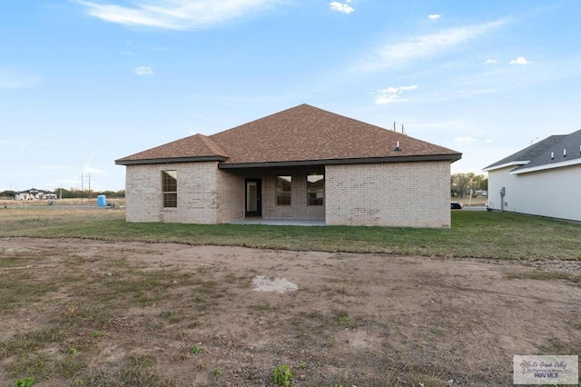 rear view of property featuring a yard and a patio area