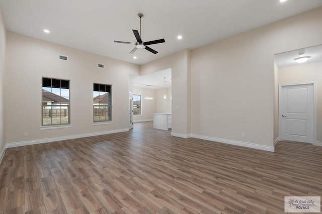 unfurnished living room featuring hardwood / wood-style flooring and ceiling fan