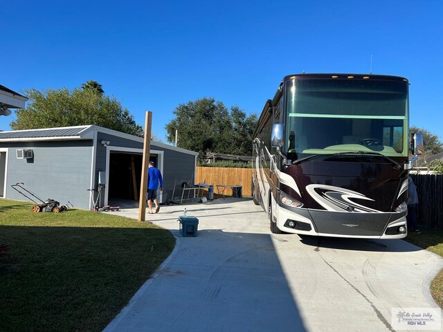 exterior space with a yard, a garage, and an outbuilding