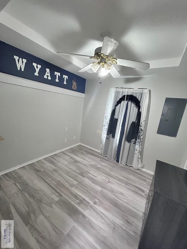 empty room featuring light wood-type flooring, electric panel, and ceiling fan