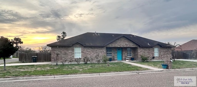 ranch-style home with a yard