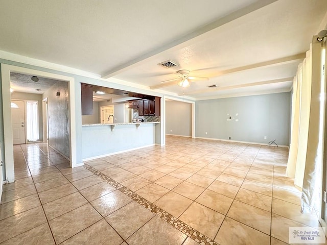 unfurnished living room with beam ceiling, sink, ceiling fan, and light tile patterned flooring