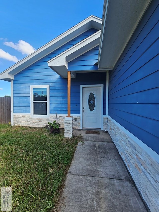 property entrance with a lawn