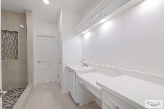 bathroom with vanity and tiled shower