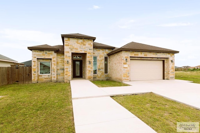 view of front of home with a garage and a front lawn