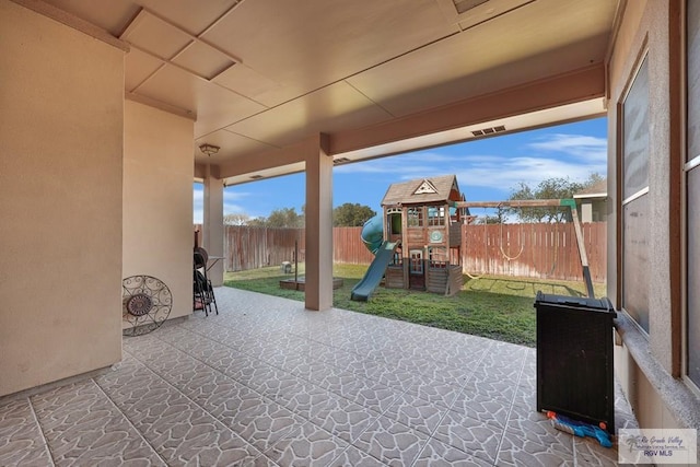 view of patio / terrace with a playground and a fenced backyard