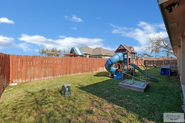 view of playground with a yard and a fenced backyard