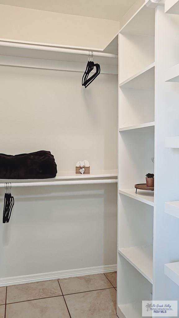 walk in closet with light tile patterned floors