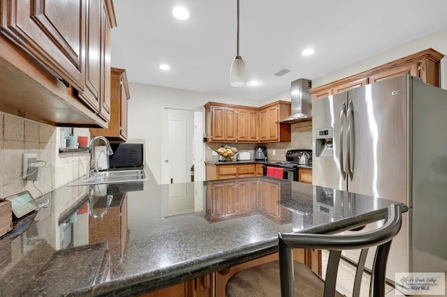 kitchen with a sink, wall chimney exhaust hood, decorative backsplash, black appliances, and a peninsula