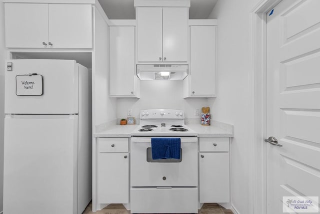 kitchen featuring white cabinets, light wood-type flooring, and white appliances