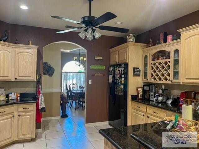 5303 Rustic Manor Dr, Brownsville, TX 78526 - kitchen with arched walkways, light tile patterned floors, ceiling fan with notable chandelier, black refrigerator with ice dispenser, and glass insert cabinets