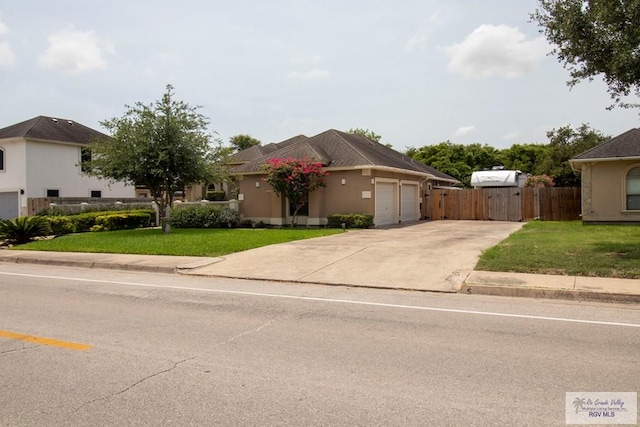 5303 Rustic Manor Dr, Brownsville, TX 78526 - single story home featuring fence, an attached garage, concrete driveway, and a front lawn