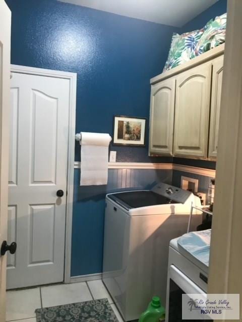5303 Rustic Manor Dr, Brownsville, TX 78526 - washroom featuring cabinet space, light tile patterned flooring, washing machine and dryer, and wainscoting
