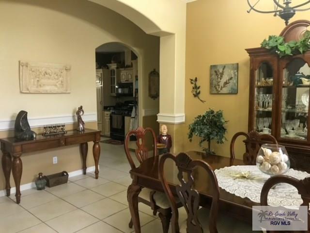 5303 Rustic Manor Dr, Brownsville, TX 78526 - dining area with arched walkways and light tile patterned floors