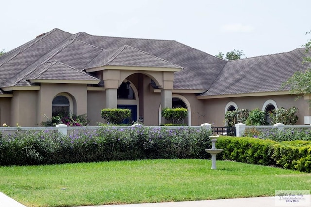 5303 Rustic Manor Dr, Brownsville, TX 78526 - mediterranean / spanish house featuring fence, stucco siding, and a front yard