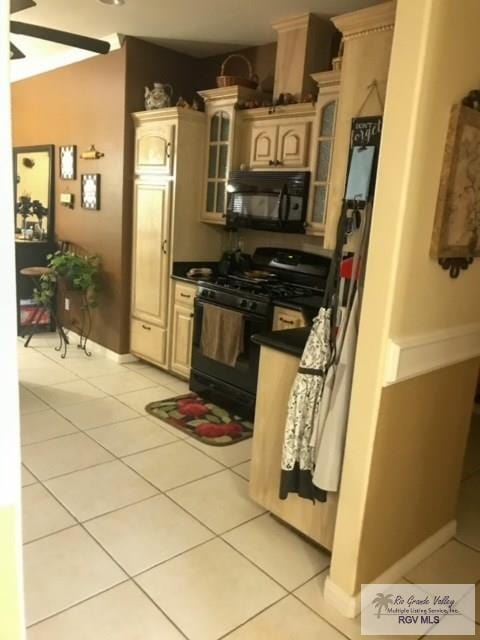 5303 Rustic Manor Dr, Brownsville, TX 78526 - kitchen with light tile patterned floors, black appliances, dark countertops, and glass insert cabinets