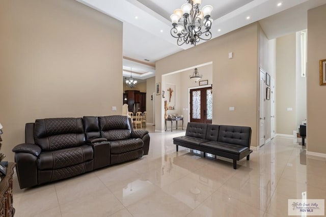 living area with baseboards, recessed lighting, a raised ceiling, a high ceiling, and an inviting chandelier