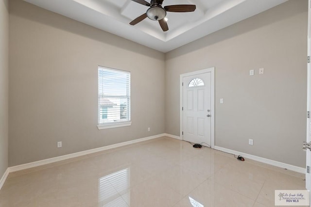 entrance foyer with baseboards, ceiling fan, light tile patterned floors, and a raised ceiling