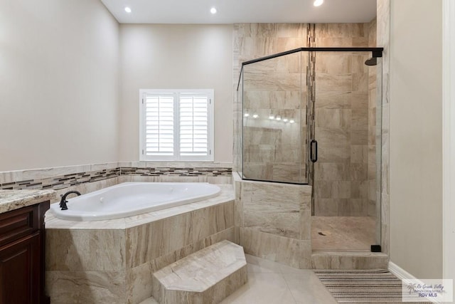 bathroom featuring a stall shower, tile patterned flooring, vanity, and a garden tub