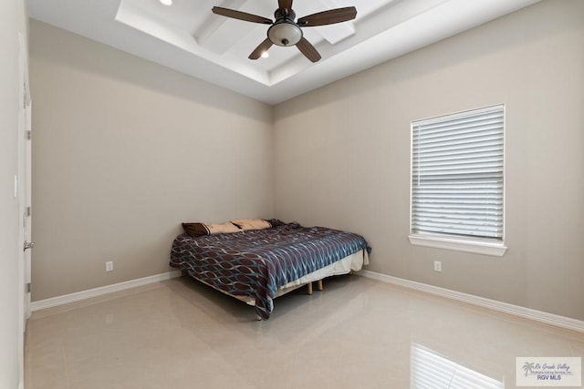 bedroom featuring baseboards, a ceiling fan, and a raised ceiling