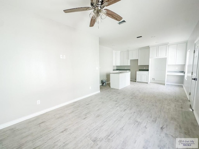 unfurnished living room featuring ceiling fan and light hardwood / wood-style floors