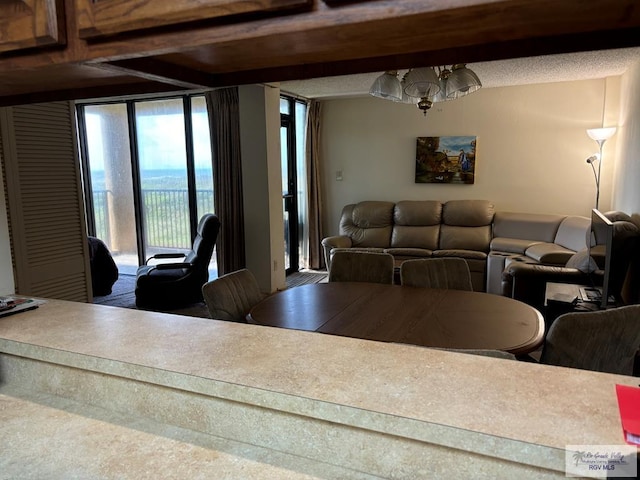 dining area with beamed ceiling and an inviting chandelier