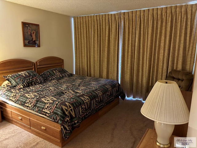 bedroom with dark colored carpet and a textured ceiling