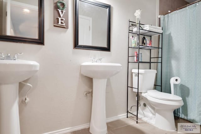 bathroom featuring tile patterned floors, curtained shower, toilet, and sink