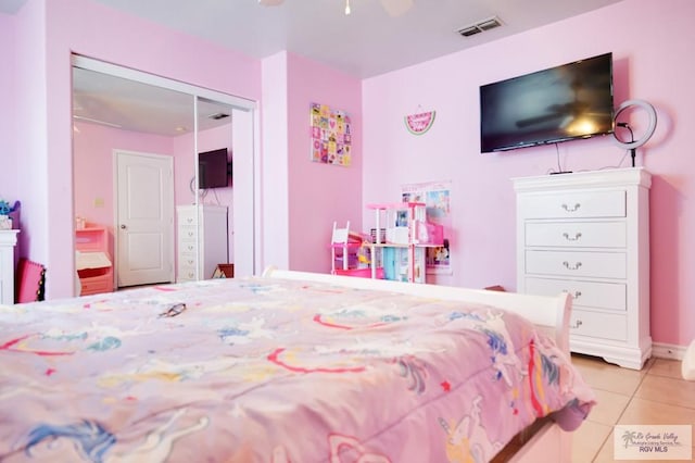 tiled bedroom with ceiling fan and a closet