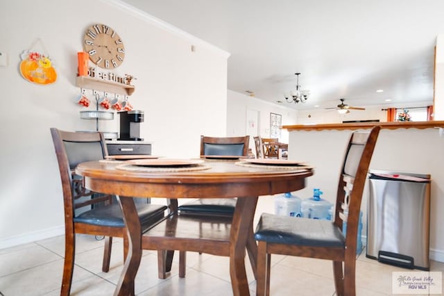 tiled dining space with ceiling fan with notable chandelier