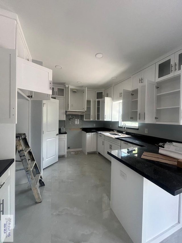 9910 Hawk Dr, Harlingen, TX 78550 - kitchen with concrete flooring, glass insert cabinets, open shelves, dark countertops, and recessed lighting