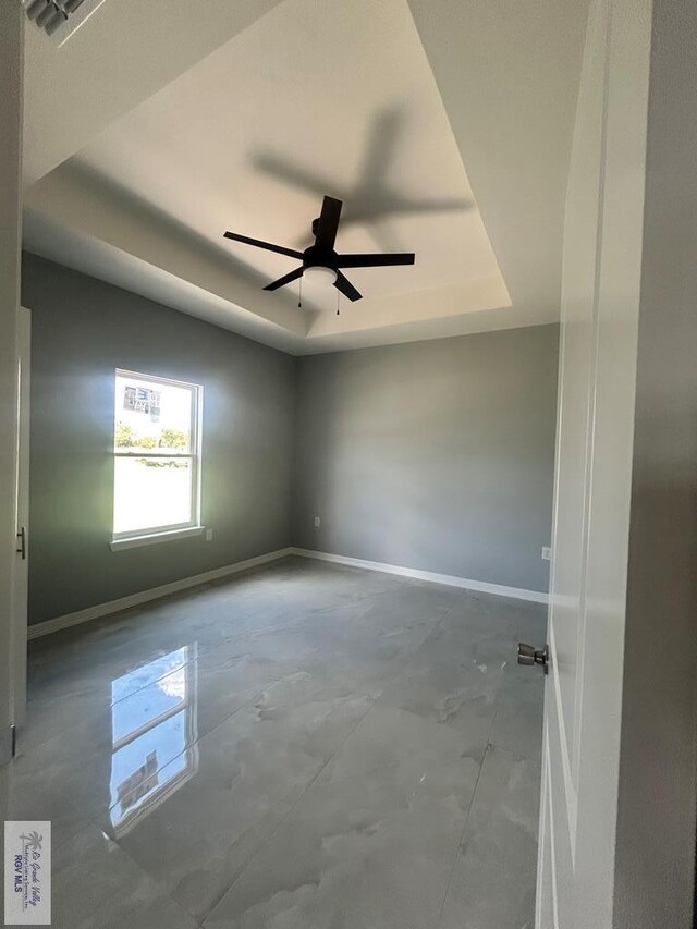 9910 Hawk Dr, Harlingen, TX 78550 - empty room featuring a raised ceiling, ceiling fan, and concrete floors