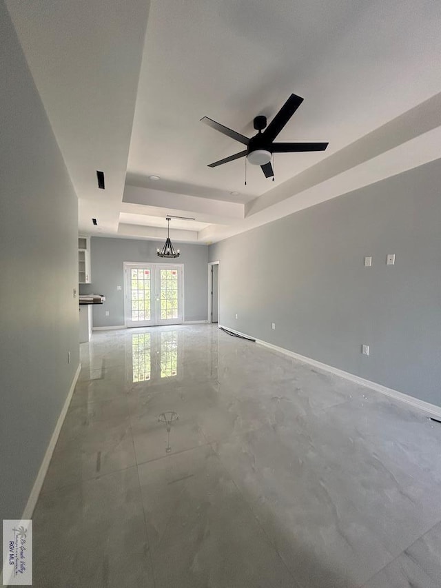 9910 Hawk Dr, Harlingen, TX 78550 - unfurnished room featuring a tray ceiling, concrete flooring, a ceiling fan, french doors, and a chandelier