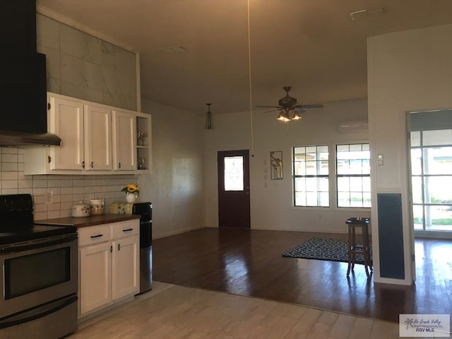 kitchen with white cabinetry, stainless steel range with electric stovetop, plenty of natural light, and extractor fan