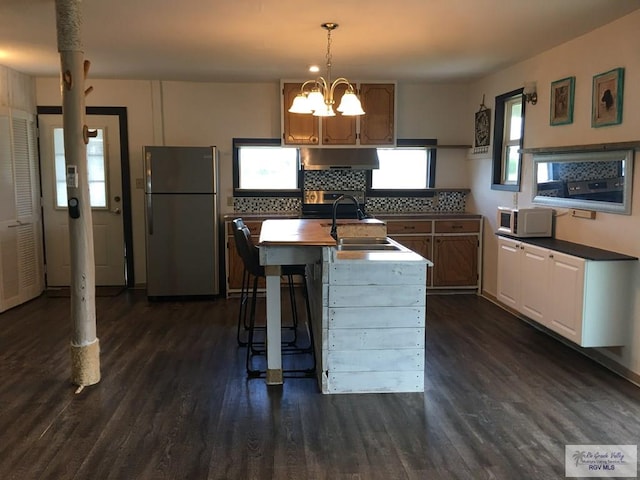 36282 Fm 2480, Los Fresnos, TX 78566 - kitchen featuring dark wood-style floors, under cabinet range hood, a sink, freestanding refrigerator, and white microwave
