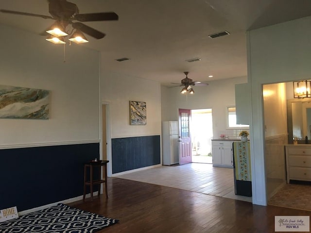 kitchen with white cabinetry, ceiling fan, wood-type flooring, and white fridge