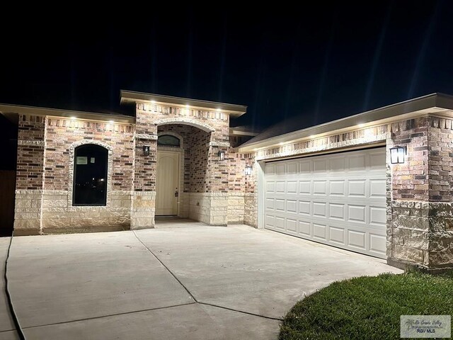 1521 Stirrup Cir, San Benito, TX 78586 - french country home featuring driveway, brick siding, stone siding, and a garage